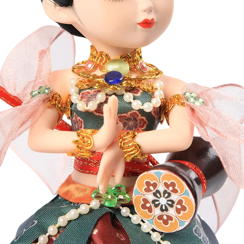 Detail of 9-inch Dunhuang doll's red silk skirt, green sash, and colorful drumming instrument.