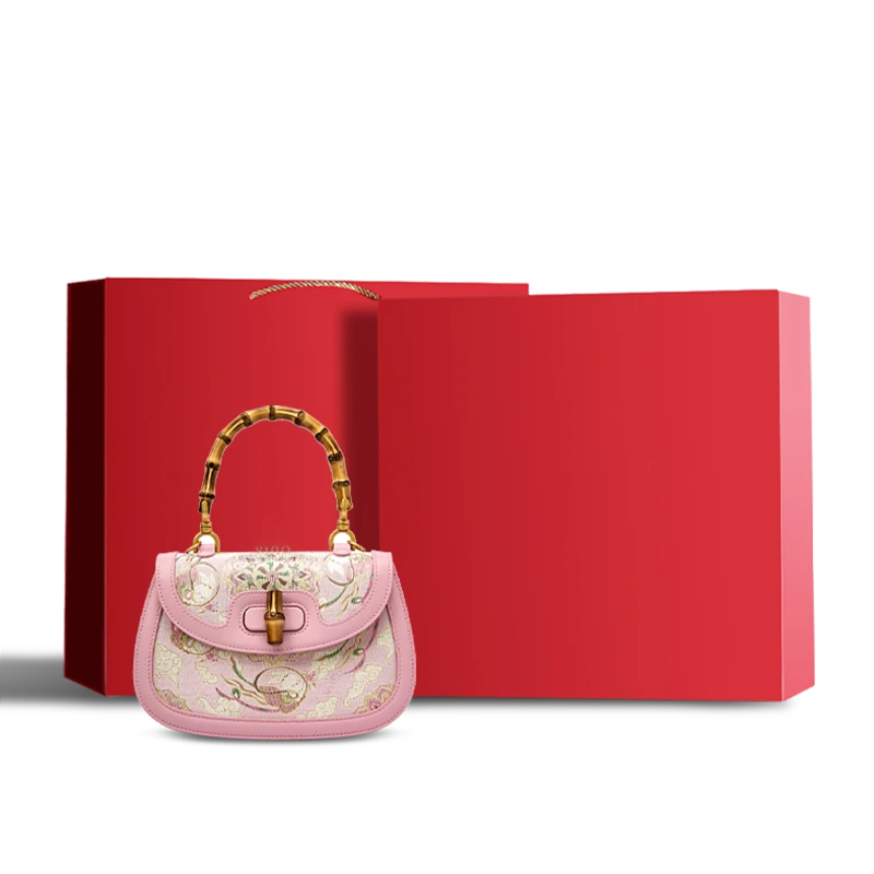 Red gift box packaging for the pink Song brocade handbag with bamboo handle, ready for gifting.