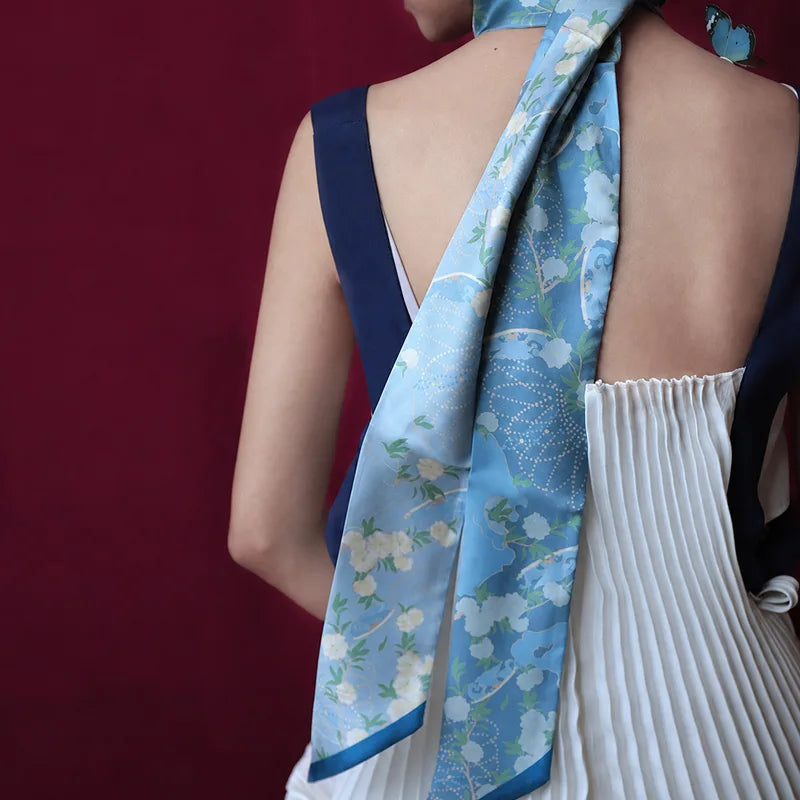 Woman wearing the Chinese Blooming Peony Mulberry Silk Twilly draped from the neck down the back for an elegant long scarf look.