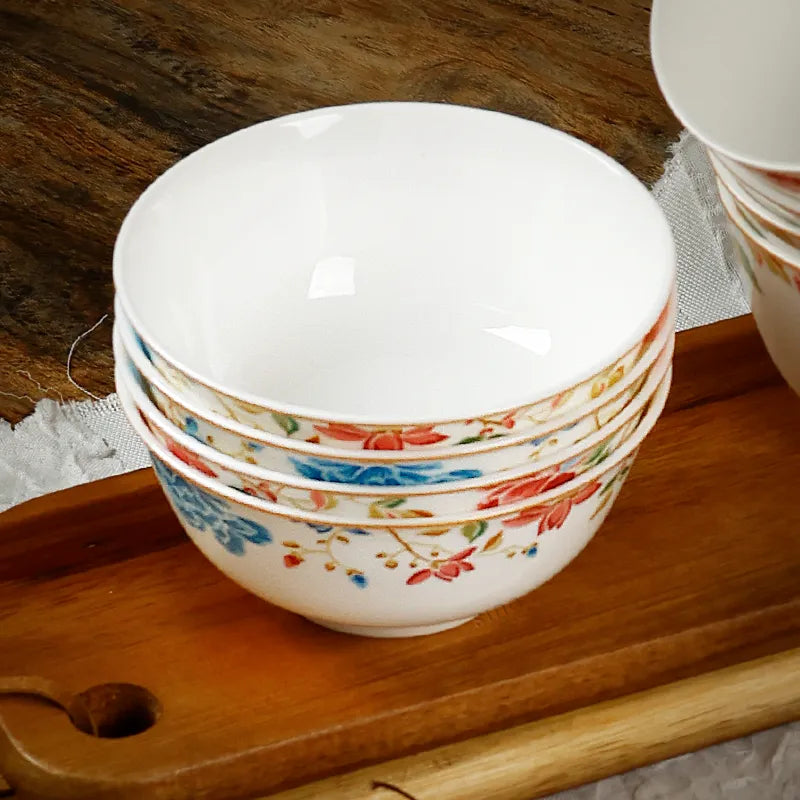 Four chinoiserie bowls stacked on wooden shelf, 45-degree view.