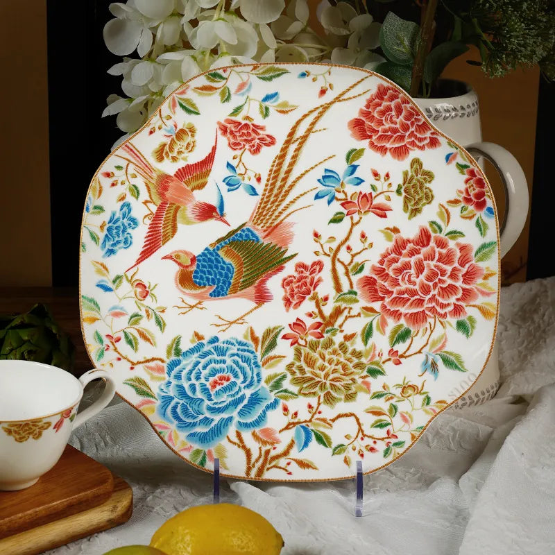 Floral bone china plate upright with cup beside it.