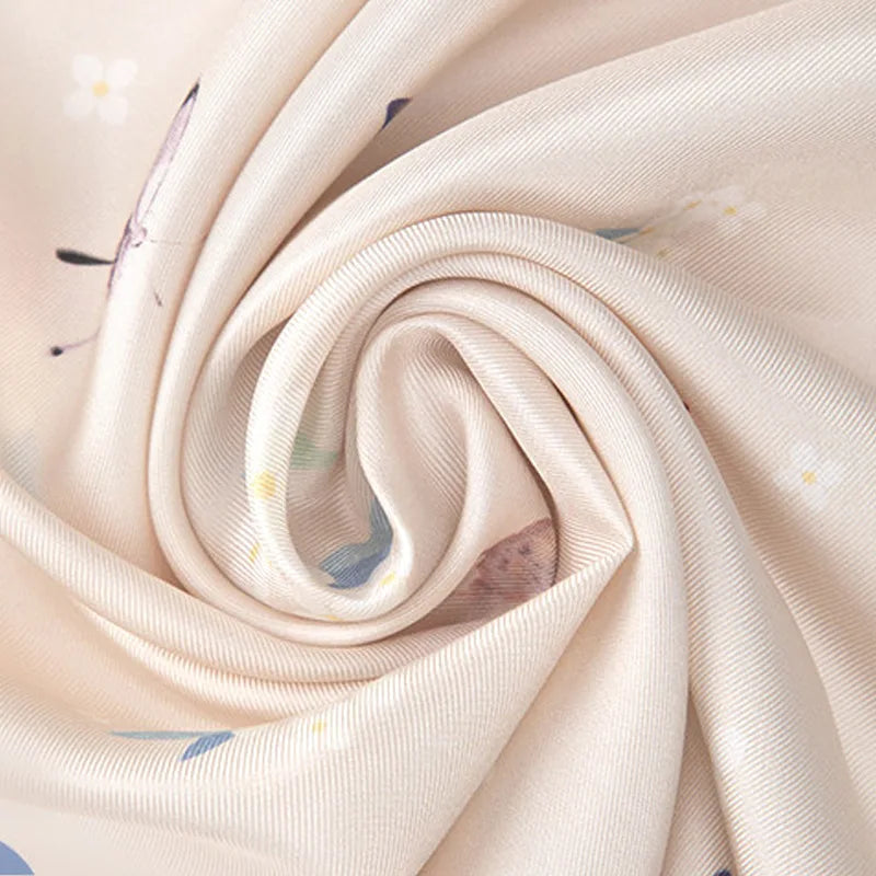 Close-up of 14 momme mulberry silk twill on the Butterfly Dream Square Scarf showing its smooth texture and subtle sheen.
