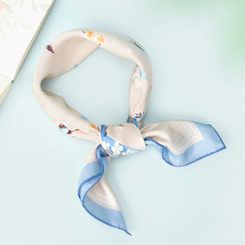 Butterfly Dream Mulberry Silk Square Scarf tied in a classic neck scarf style with soft beige silk and blue edging.