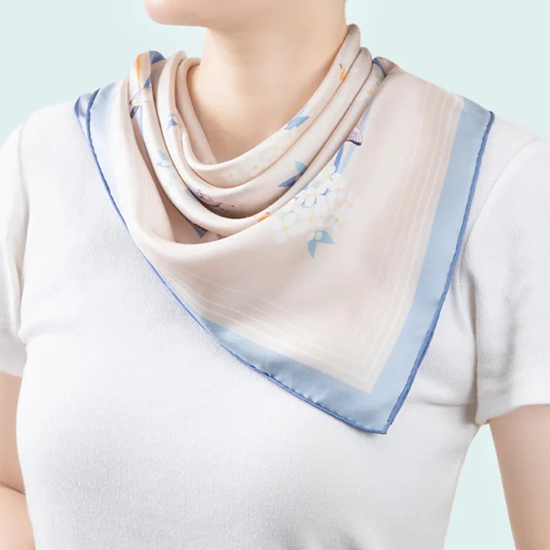 Woman wearing the Butterfly Dream Mulberry Silk Square Scarf as an elegant neck scarf with a white top.