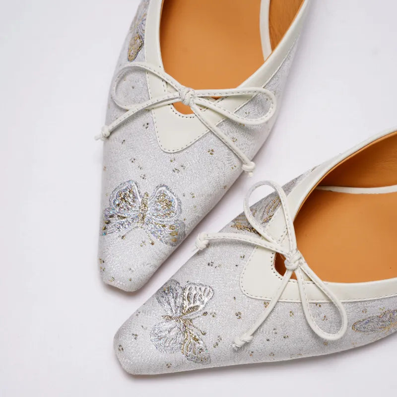 Close-up of Butterfly Reverie Song Brocade kitten heel mules highlighting delicate butterfly motifs, woven texture, and bow embellishment.
