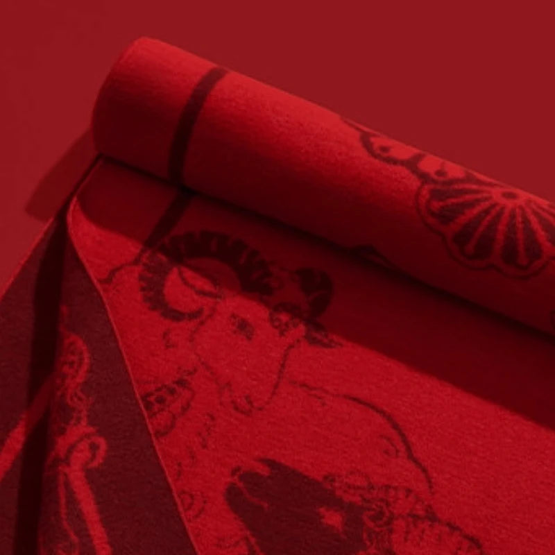 Close-up of the soft red scarf fabric showing its cashmere-touch texture and intricate jacquard-inspired pattern.