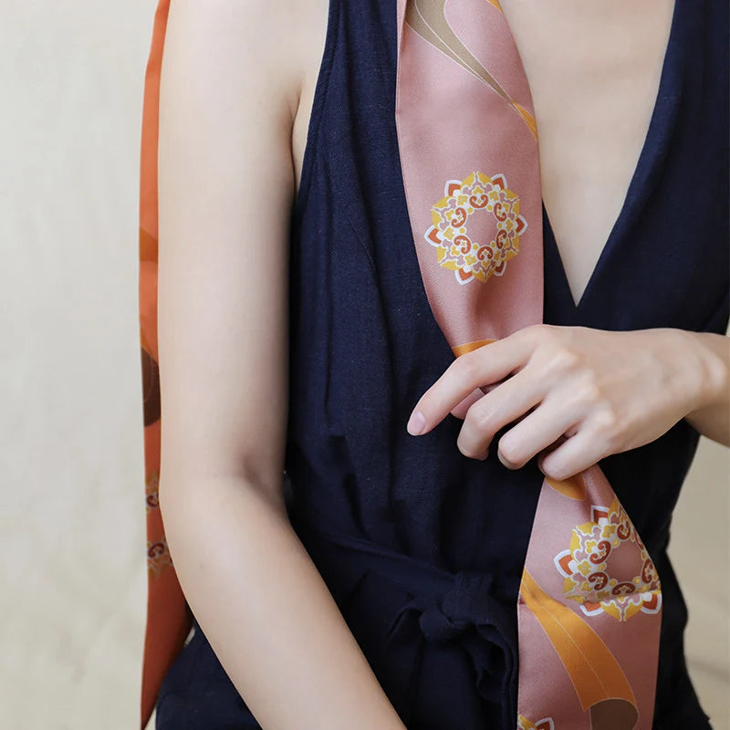 Close-up of a model styling the Chinese Dunhuang Motif Print Mulberry Silk Twilly 160x7.3 cm, featuring Dunhuang-inspired ornamental motifs.
