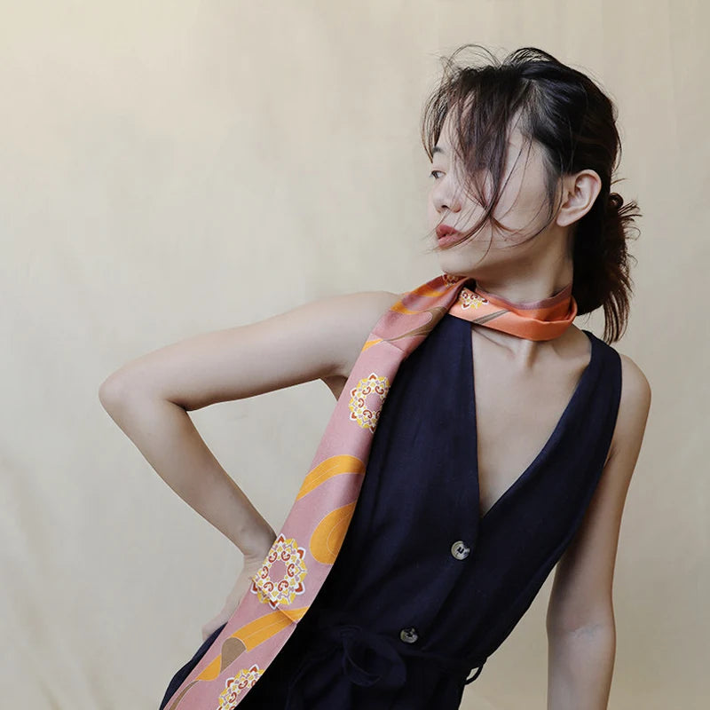 Model wearing the Chinese Dunhuang Motif Print Mulberry Silk Twilly 160x7.3 cm around the neck in an elegant long scarf styling.