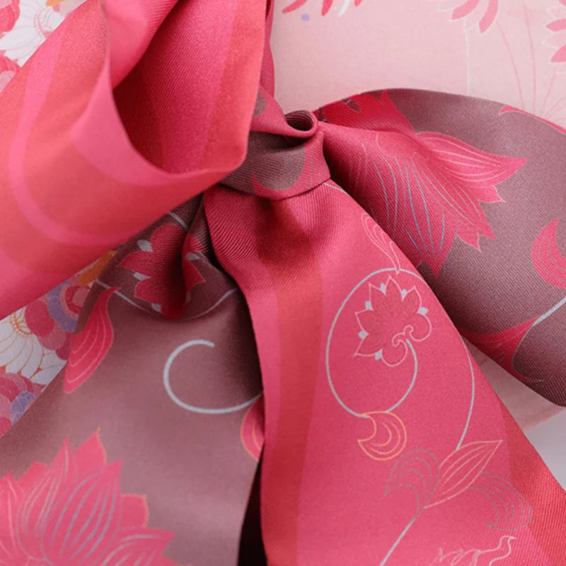 Close-up of the Chinese Dunhuang Motif Print Mulberry Silk Twilly 160x7.3 cm showing pink lotus-inspired pattern and smooth silk texture.