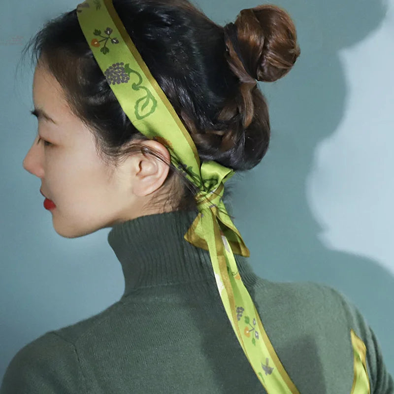 Woman wearing the Chinese Grape Vine Print Mulberry Silk Twilly as a headband, showing the elegant green botanical print.