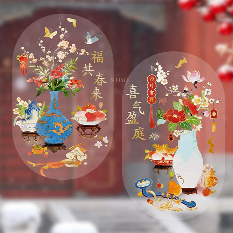 Two Chinese New Year window clings featuring colorful floral arrangements, porcelain vases, gold calligraphy, and auspicious motifs displayed on glass.