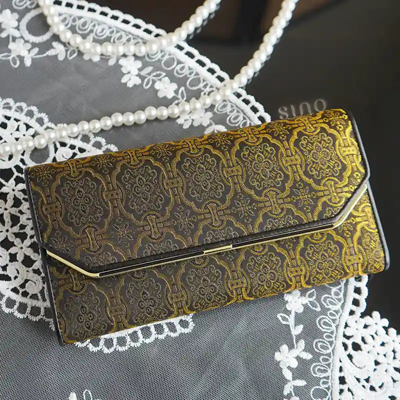 Lifestyle view of the Chinese Song Brocade Dingsheng Motif Leather Long Wallet styled with lace and pearl accessories.