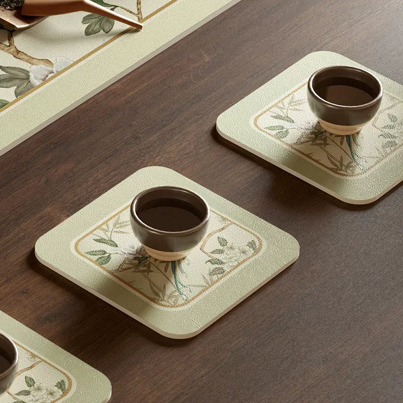 Chinoiserie jade green leather cup coaster with teacup on top.