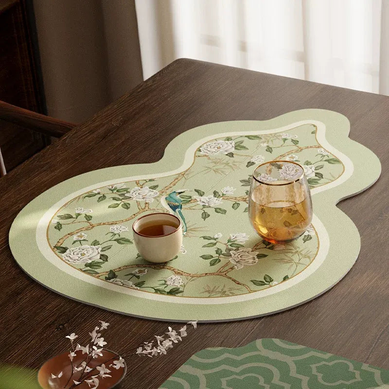 Gourd-shaped chinoiserie jade green leather coaster with teacup on top.