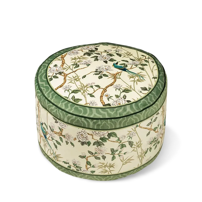 Chinoiserie jade green living room couch cushion pouf with a floral and bird pattern shown on a white background.