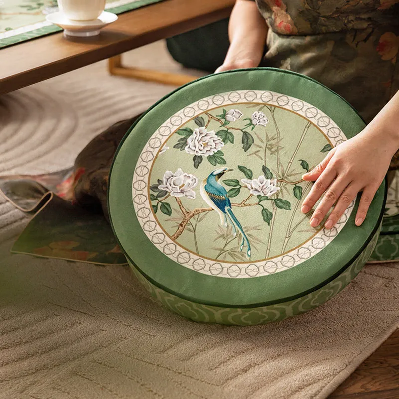 Angled overhead view of model holding Style A tatami pouf to show the floral and bird pattern.