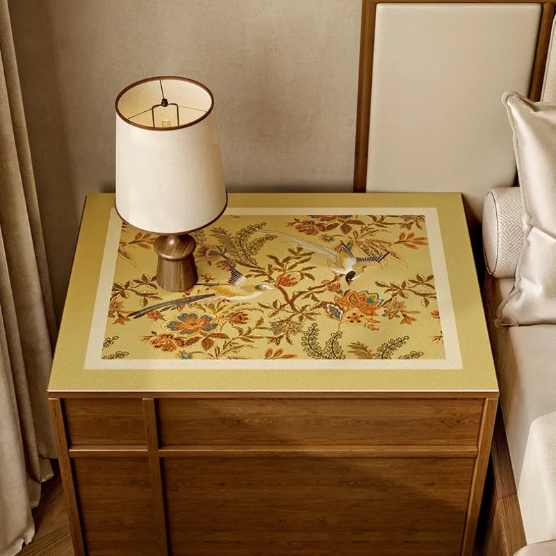 Autumn Splendor faux leather bedside table protector featuring golden floral and long-tailed bird motifs.