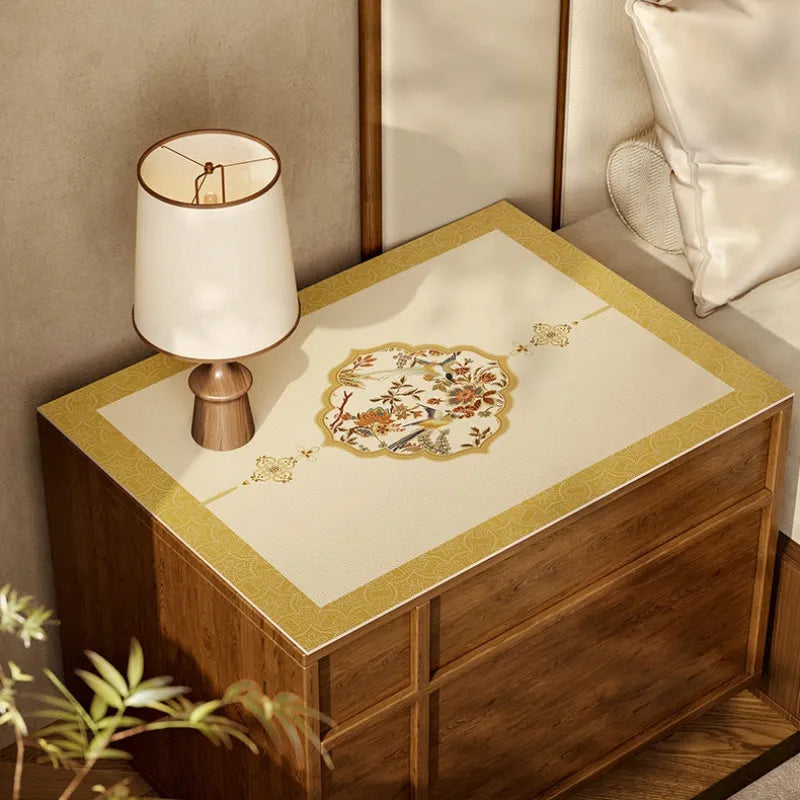 Ivory Autumn Splendor Chinoiserie leather nightstand protector mat styled on a wooden bedside cabinet.
