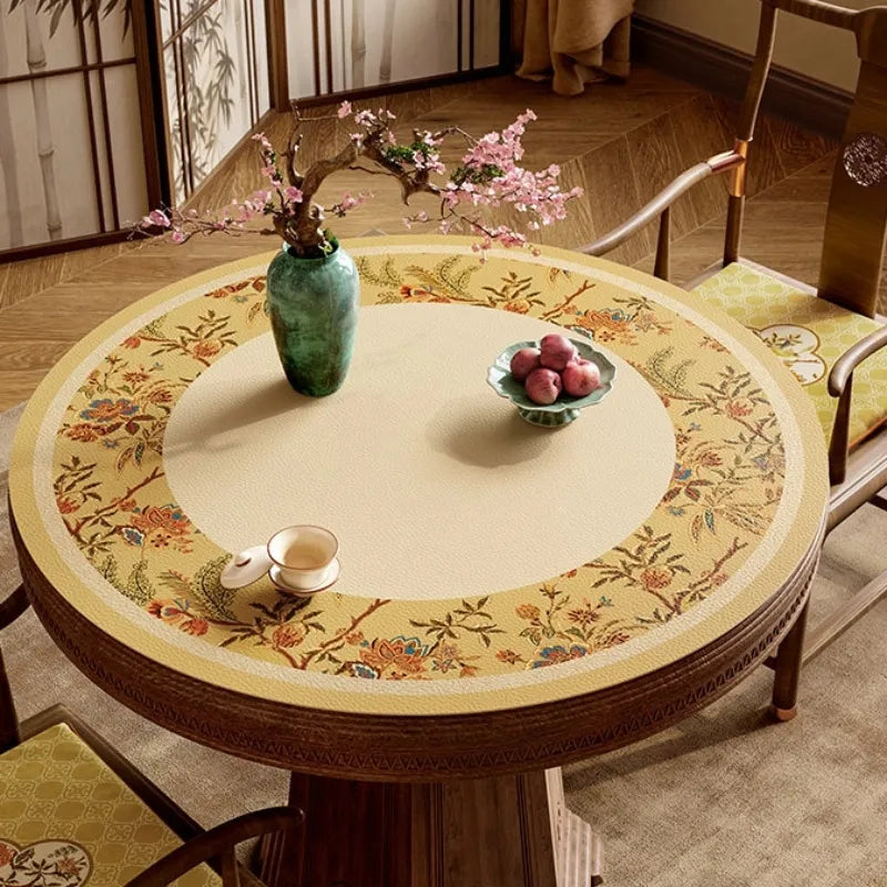 Autumn Splendor round leather dining table protector with golden floral motifs styled in an elegant Chinoiserie dining room.