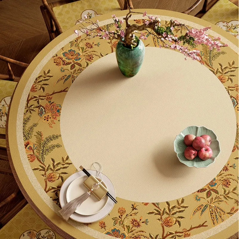 Top view of Autumn Splendor round dining table mat featuring a golden floral border and easy-clean leather surface.