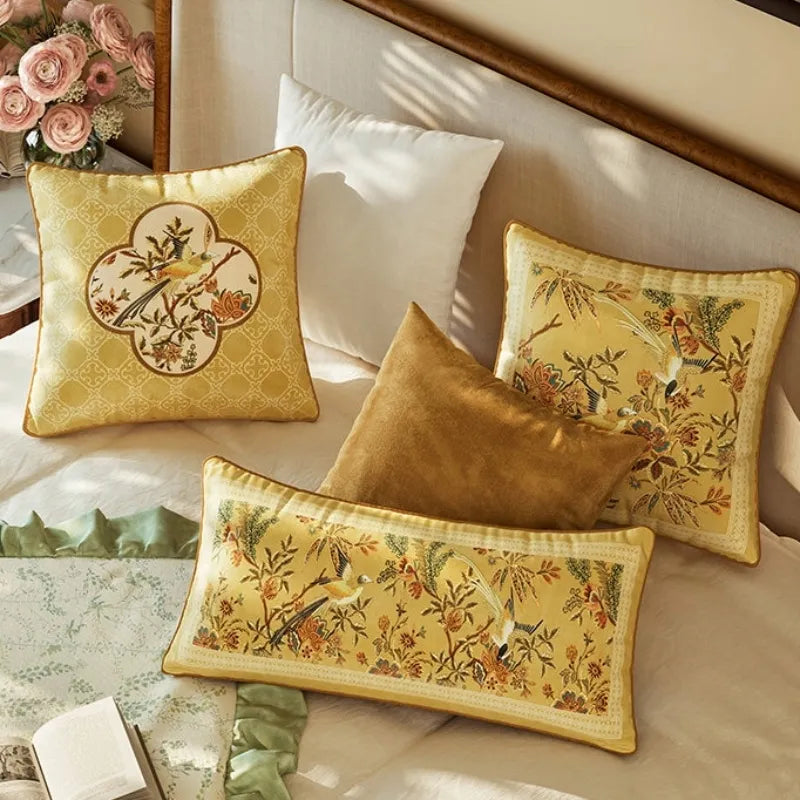 Autumn Splendor yellow decorative pillows with floral and bird motifs styled on a bed for elegant Chinoiserie bedroom and fall home decor.