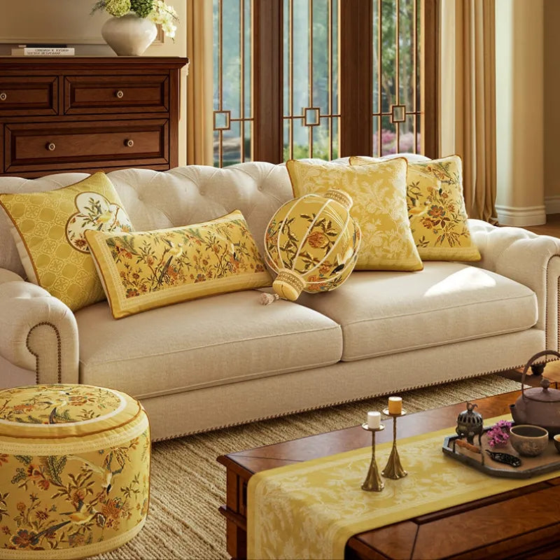 Yellow Autumn Splendor decorative throw pillows styled on a cream couch with matching Chinoiserie home accents for seasonal living room decor.