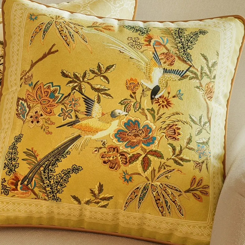 Close-up of Autumn Splendor yellow Chinoiserie throw pillow with graceful birds, flowers and botanical motifs in warm autumn tones.