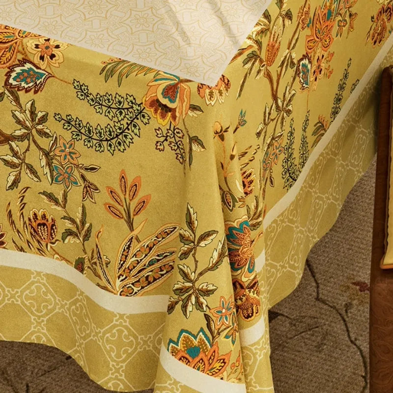 Close-up of Autumn Splendor yellow Chinoiserie tablecloth showing detailed floral pattern, decorative border and soft fabric drape.