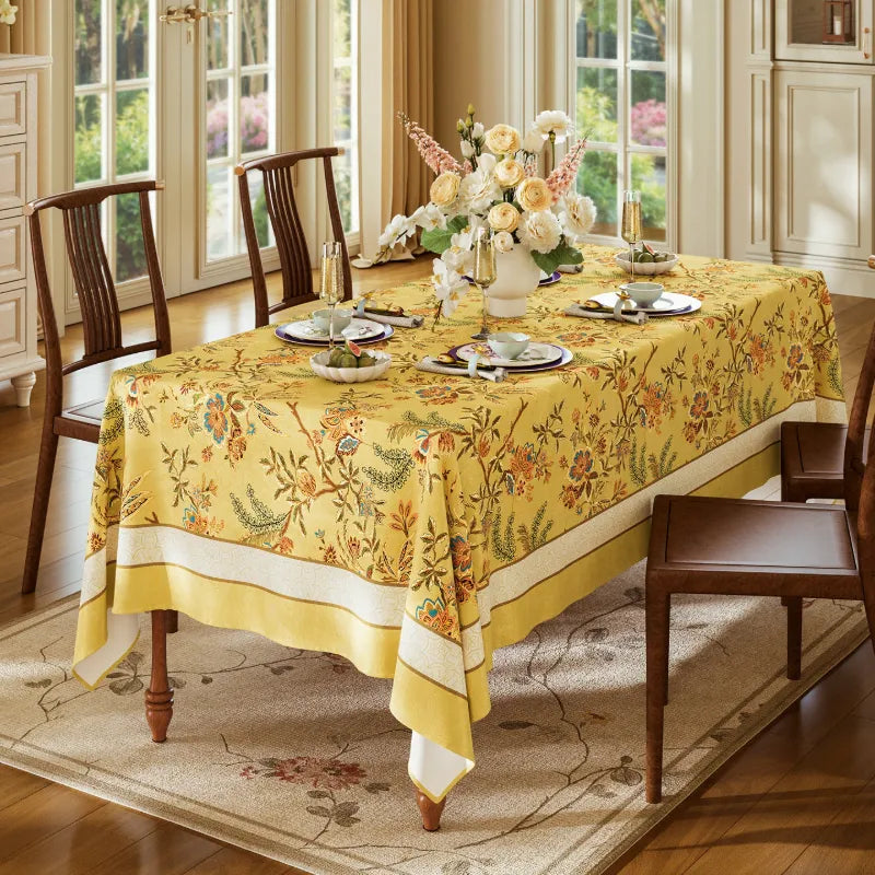 Overhead view of Autumn Splendor yellow Chinoiserie dining tablecloth with floral motifs and coordinated place settings for seasonal entertaining.