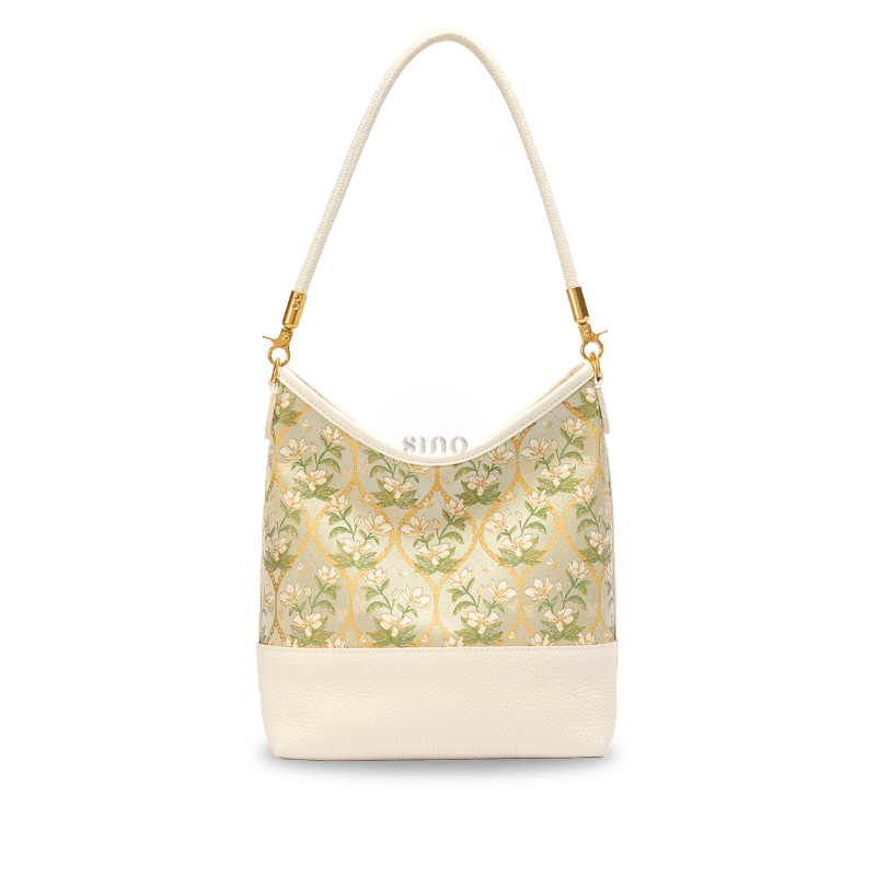 Front view of the Chinoiserie Luxury Dayun Brocade Verdant Floral Leather Shoulder Bag with ivory leather and green floral brocade panel.