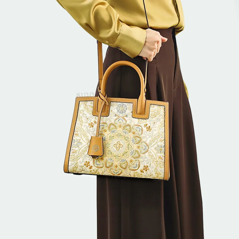 Model wearing leather handbag as shoulder bag at hip level.