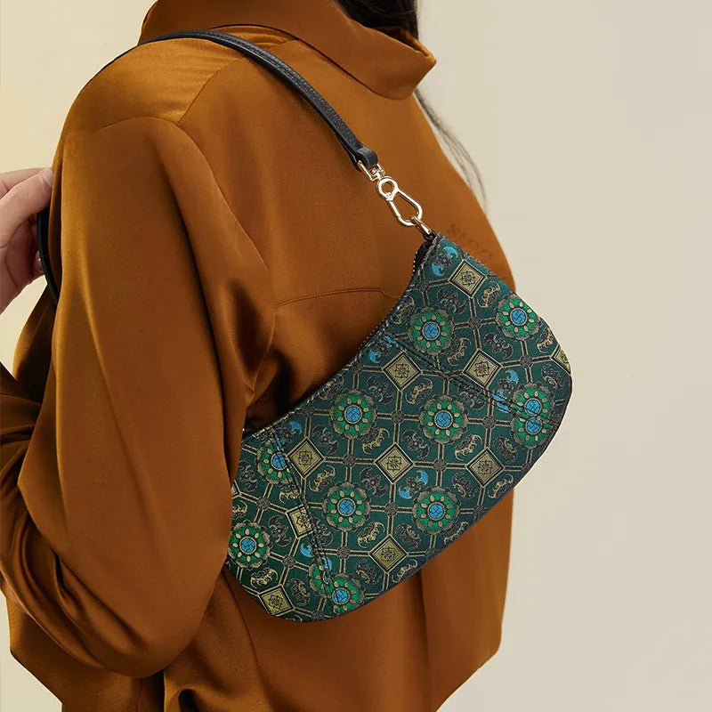 Model carrying green shoulder bag on single shoulder, Chinoiserie Song Brocade silk design.
