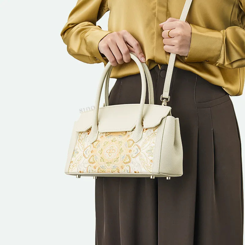 Model crossbody carrying chinoiserie luxury lotus motif leather handbag.