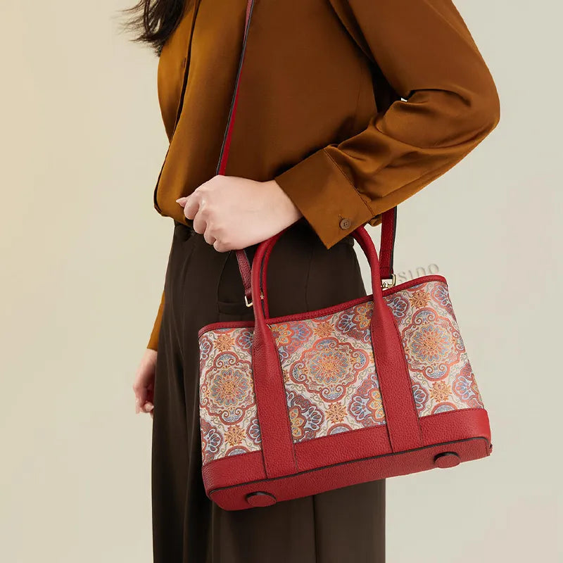 Side view of model wearing the Chinoiserie luxury red Song brocade Baoxiang floral motif tote bag on one shoulder, holding the strap with one hand.