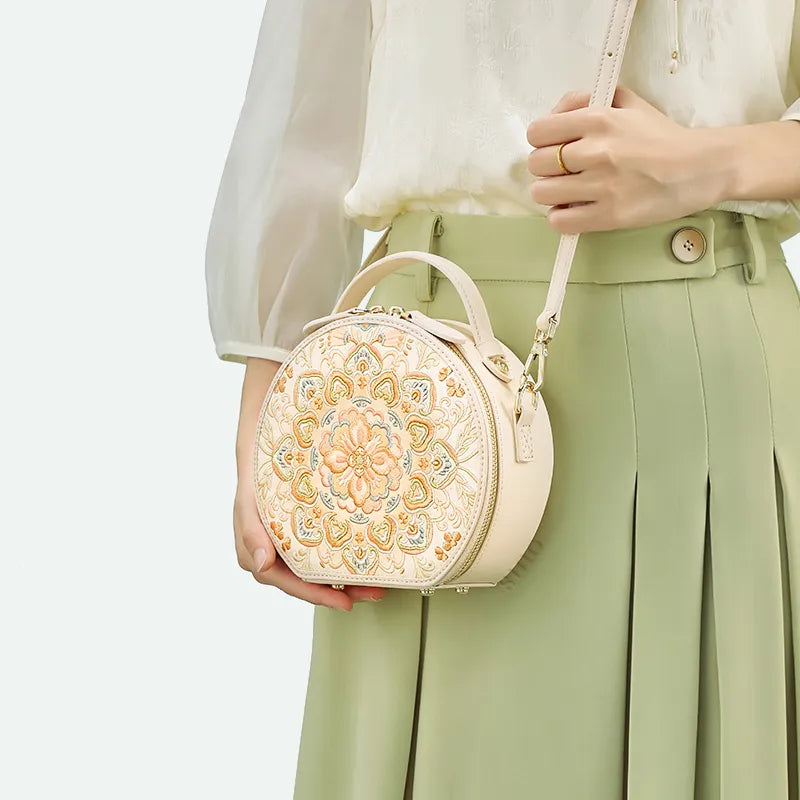 Crossbody carry at waist level showcasing embroidered luxury bag.