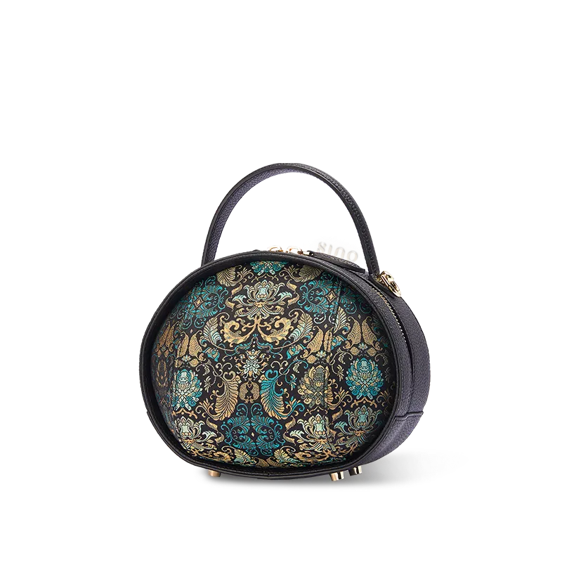 Side view of black Song Brocade handbag with Plantain Leaf Pattern on white background.