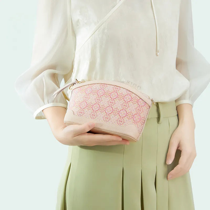 Model holding clutch in right hand, showcasing carry style.