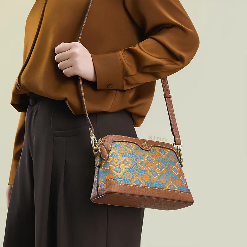Model standing sideways wearing the Ruyi Motif clutch bag as a shoulder bag.