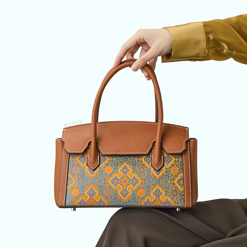 Seated model holding top handle, bag on lap.