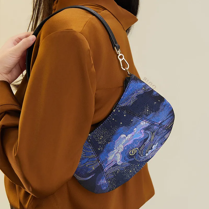 Model carrying starry night blue shoulder bag on single shoulder, Chinoiserie Song Brocade silk design.