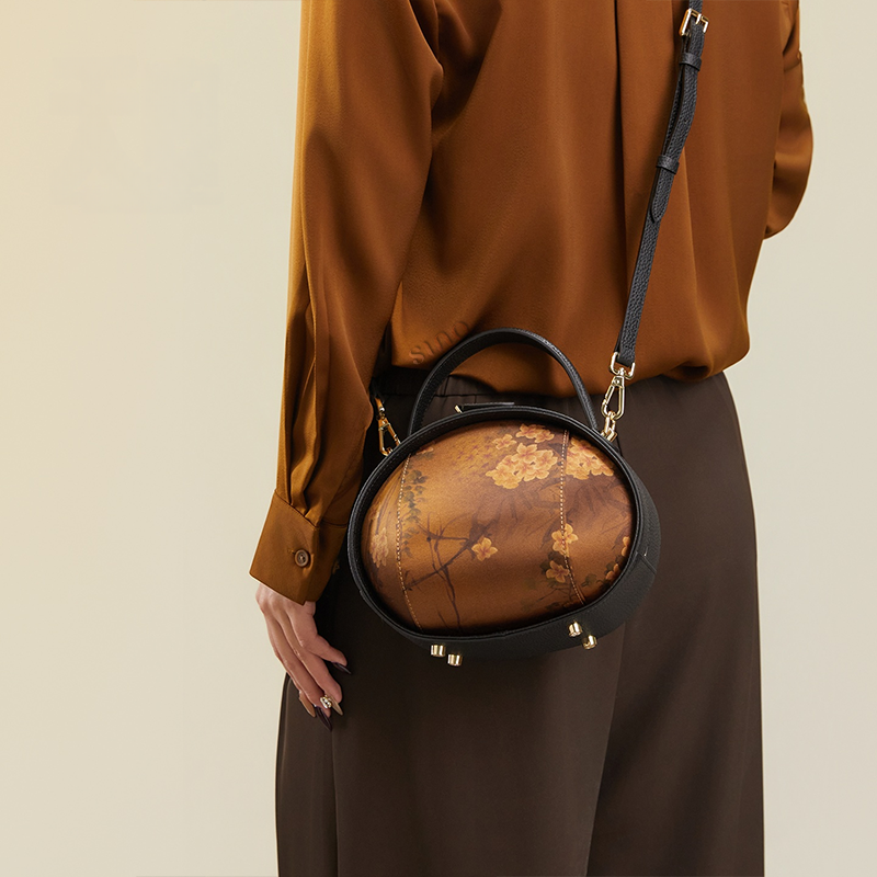 Model standing back with black Xiangyunsha handbag (Plum Blossom Print) crossbody.