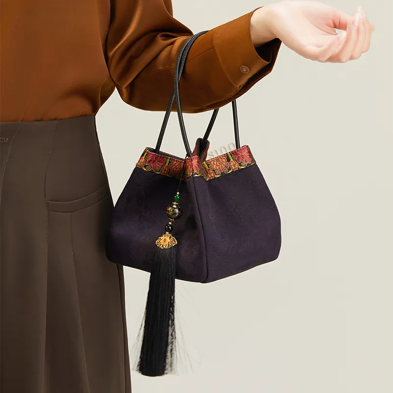 Model carrying purple bucket bag on arm, highlighting Chinoiserie design.