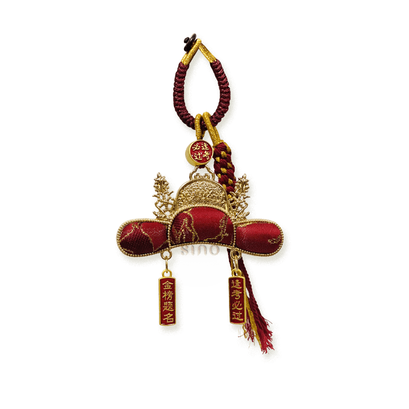 Red Nanjing Yunjin brocade Imperial Scholar Hat bag charm with gold-toned edging, braided cord, and exam blessing plaques.