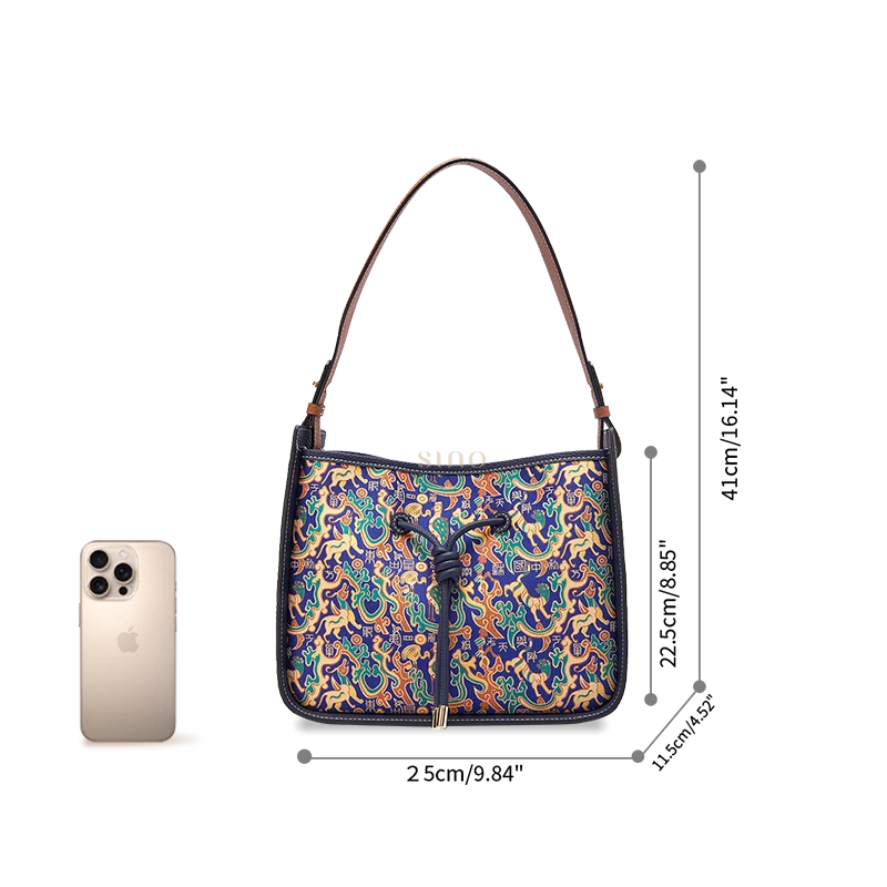 Guardian Blessing large shoulder bag size reference shown beside a smartphone for scale.