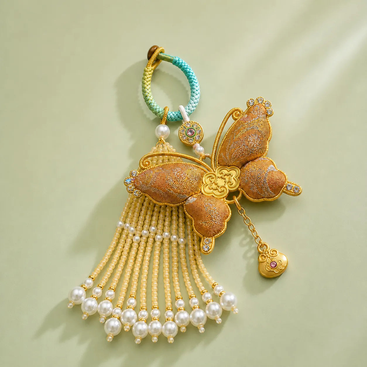 Gold Song Brocade butterfly pearl tassel bag charm with gold-tone hardware, pearl tassel strands, and an elegant woven butterfly design.