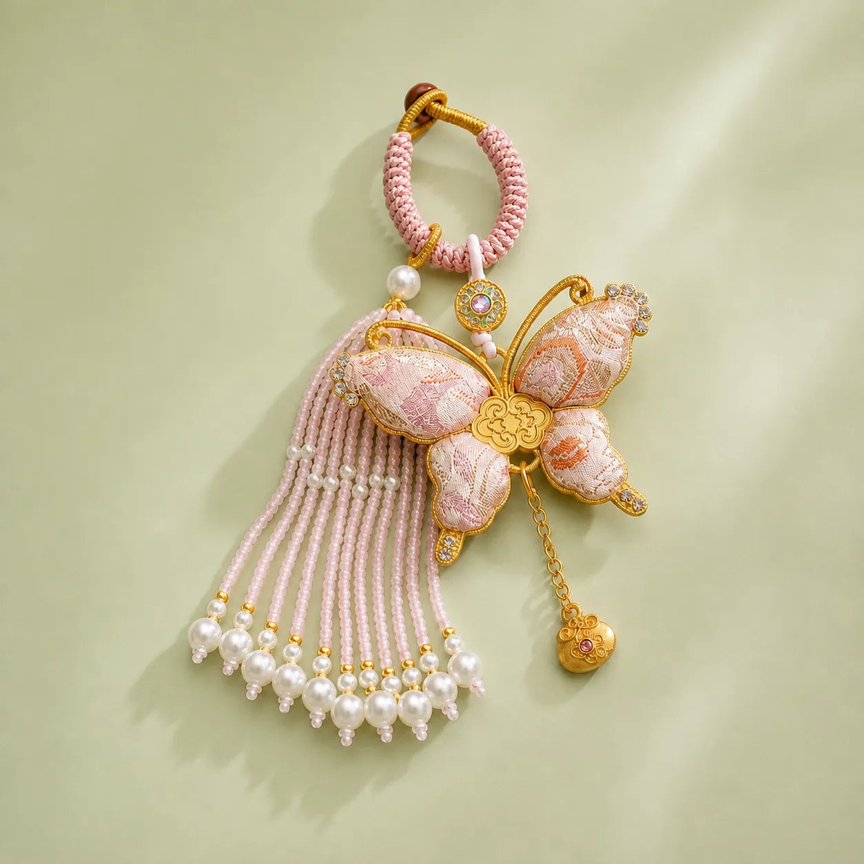 Pink Song Brocade butterfly pearl tassel bag charm with gold-tone trim, beaded tassel strands, pearl accents, and an auspicious butterfly design.