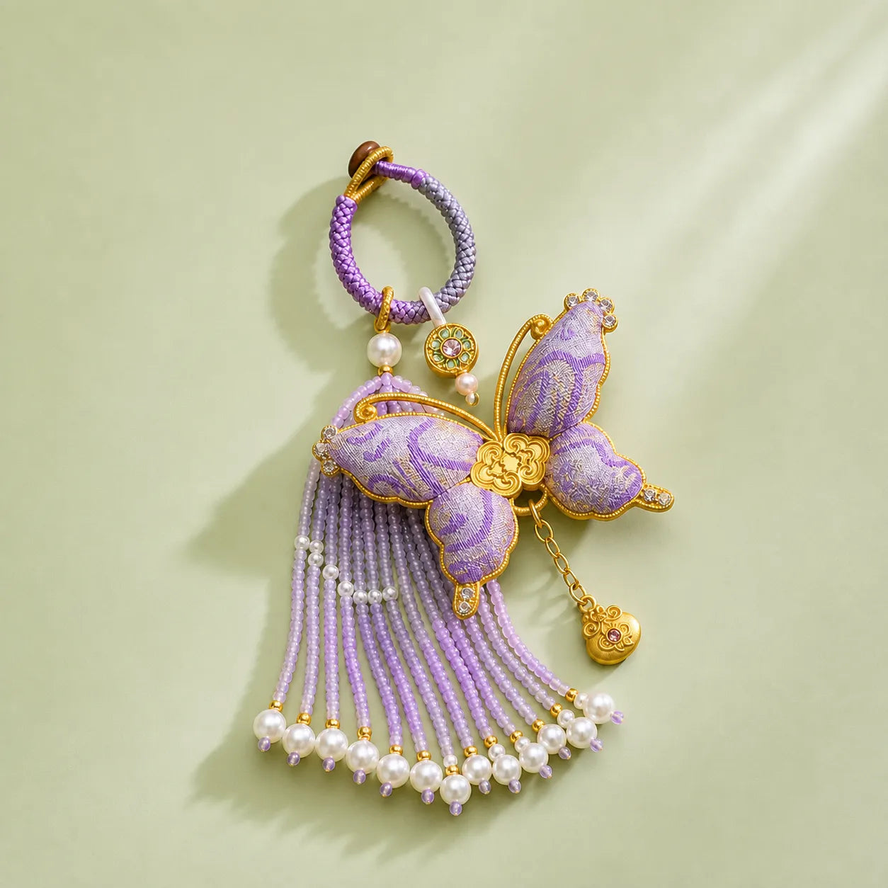 Purple Song Brocade butterfly pearl tassel bag charm with gold-tone details, pearl-beaded tassels, and a butterfly silhouette in woven brocade fabric.