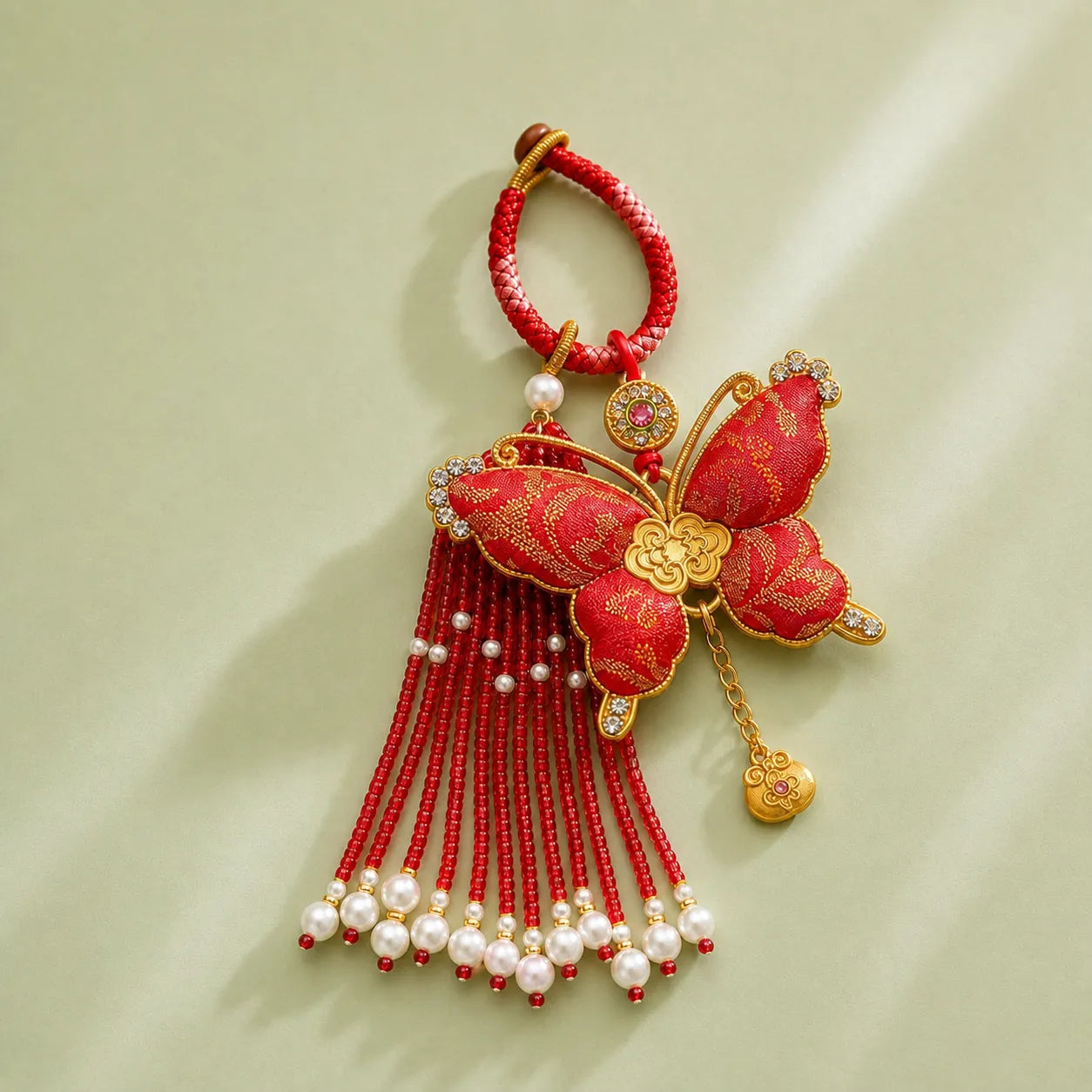 Red Song Brocade butterfly pearl tassel bag charm with gold-tone edging, red beaded tassels, pearl accents, and a festive butterfly motif.
