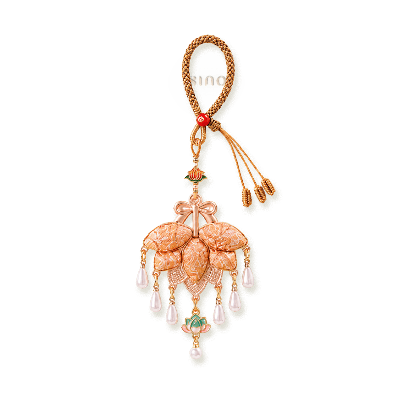 Orange Song Brocade pomelo leaf tassel bag charm with layered leaf shapes, rose-gold metalwork, lotus accents, and pearl-like drops.