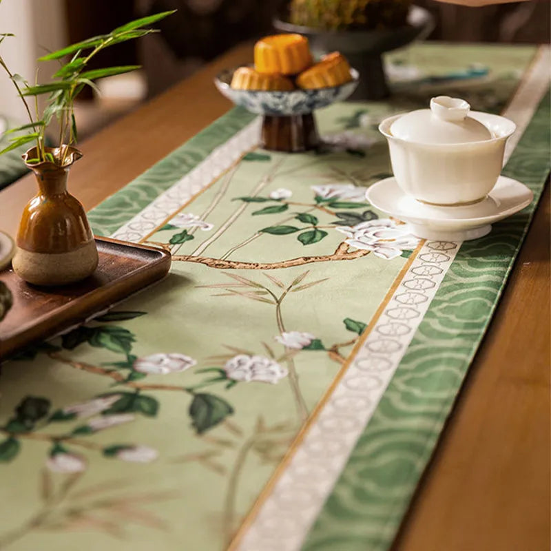 Close-up of the jade green chinoiserie long table runner showing fine stitching and an intricate weave.